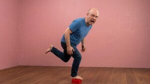 A person hopping in extreme pain after stepping on a LEGO brick illustrating why stepping on a LEGO hurts so much from pressure concentration physics foot nerve density and rapid nociceptor cascade activation